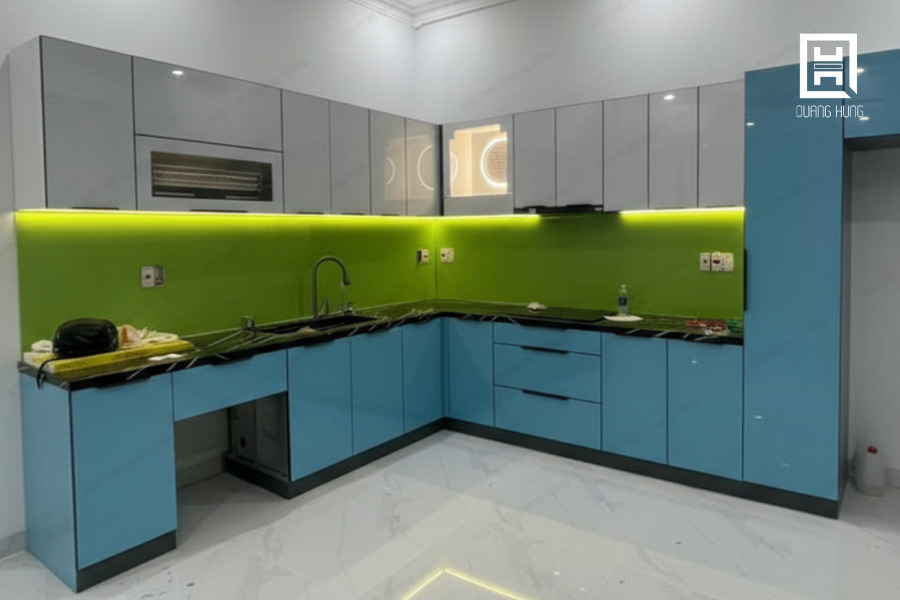 Mẫu tủ bếp chữ L làm từ khung nhôm cánh kính tone màu xanh